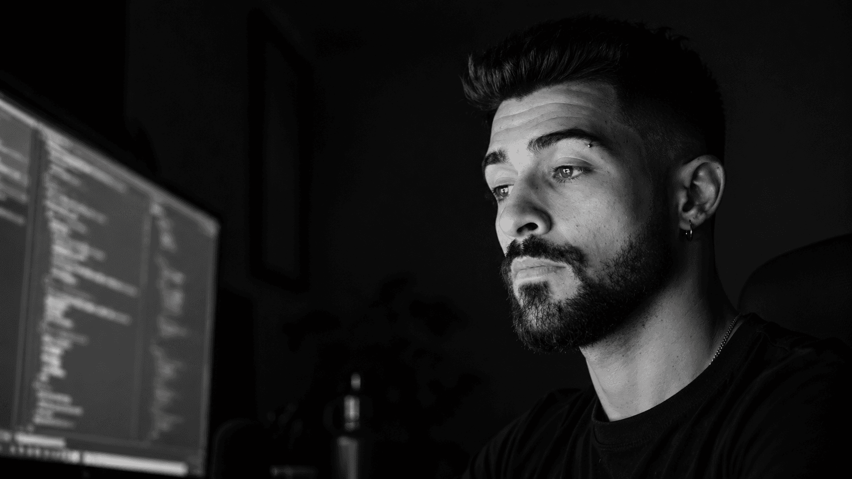 Rhuan Lucas working in front of a monitor with code